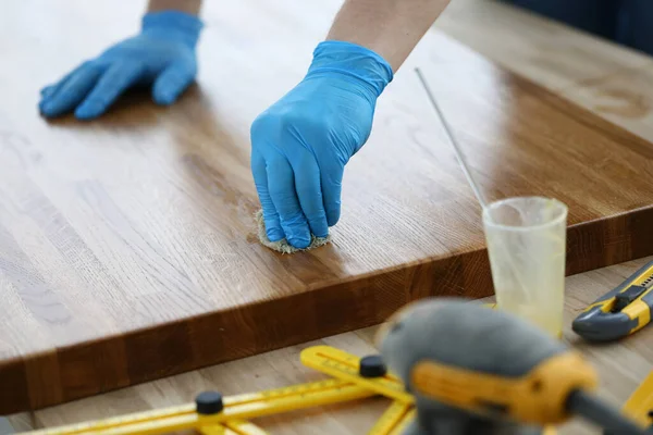Handskar hantverkare behandlar trä beläggning med skyddande skikt — Stockfoto