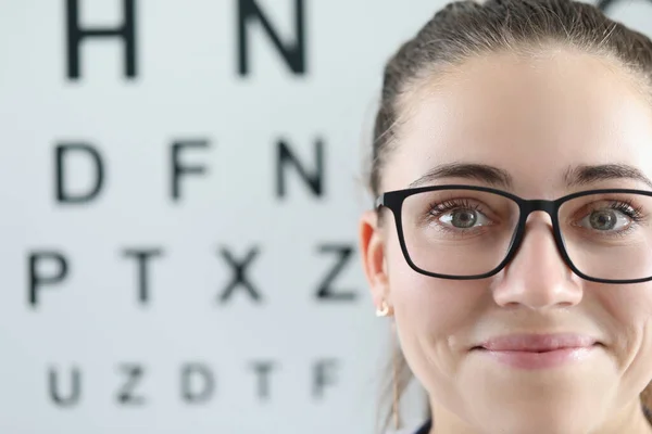 Szemüveges nő portréja a szemészeti asztal hátterében — Stock Fotó