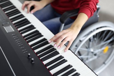 Woman in wheelchair playing synthesizer while making music clipart