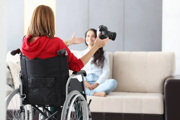 Жінка в інвалідному візку тримає камеру і фотографує модель — стокове фото