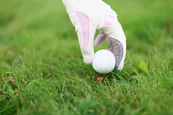 Рука в рукавичці для гольфу ставить м'яч на трійник для гольфу — стокове фото