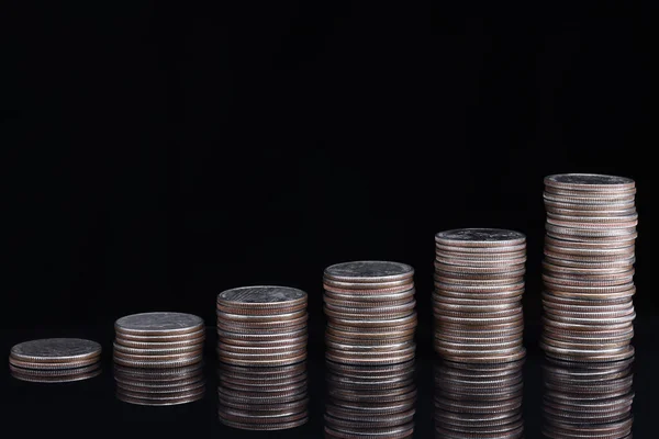 Stapel von Münzen in aufsteigender Reihenfolge auf schwarzem Hintergrund — Stockfoto