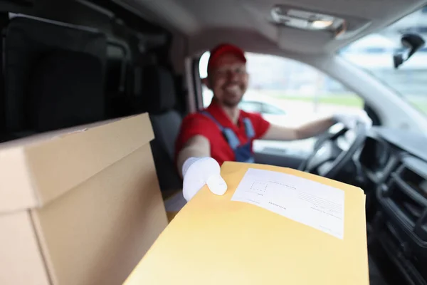 Mann liefert gelben Umschlag aus Auto-Nahaufnahme — Stockfoto