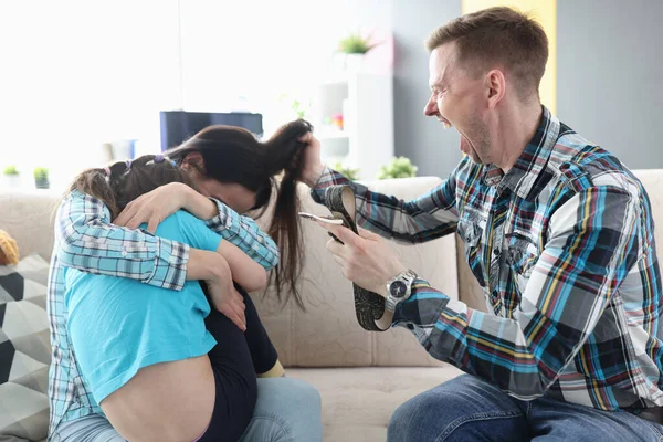 Pria dengan ikat pinggang berteriak pada gadis kecil dan wanita di rumah — Stok Foto