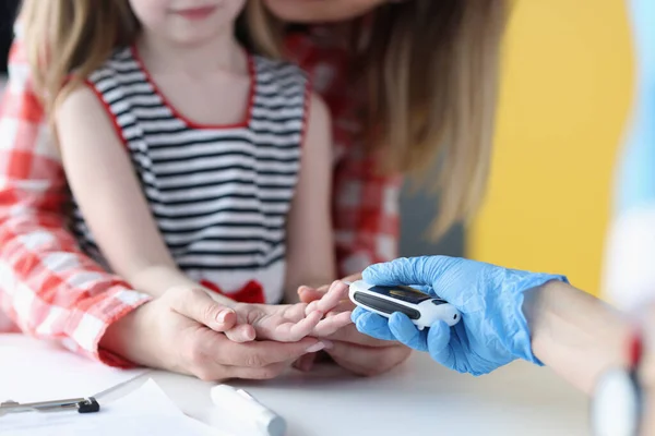 Doctor measuring blood glucose level of little girl with glucometer closeup — Stock Photo, Image