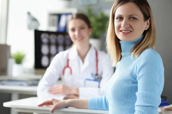 Jonge vrouw zit aan tafel bij doktersafspraak — Stockfoto