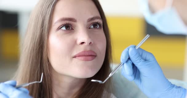 Dentiste examinant la cavité buccale de la patiente utilisant des instruments film 4k — Video
