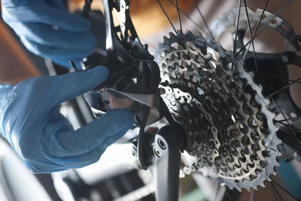 Luvas handyman reparos bicicleta traseira cassete closeup — Fotografia de Stock