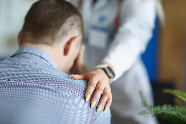 Doktor jí soucitně položil ruku na rameno rozčileného pacienta — Stock fotografie