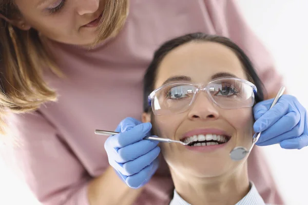 Tandarts onderzoekt mondholte van de vrouw in functie — Stockfoto