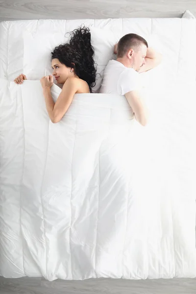 Triste homme et femme couchés avec le dos à l'autre dans le lit vue du dessus — Photo