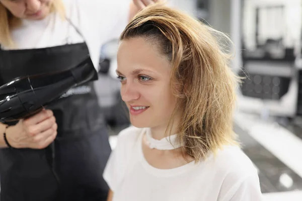 理发店里理发师用吹风机把头发吹干给女人 — 图库照片