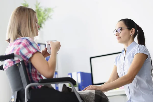 Femme handicapée en fauteuil roulant boit du thé et parle avec un psychologue — Photo