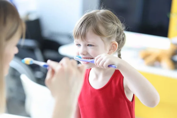 Pediatra médico ensinando menina a escovar os dentes — Fotografia de Stock
