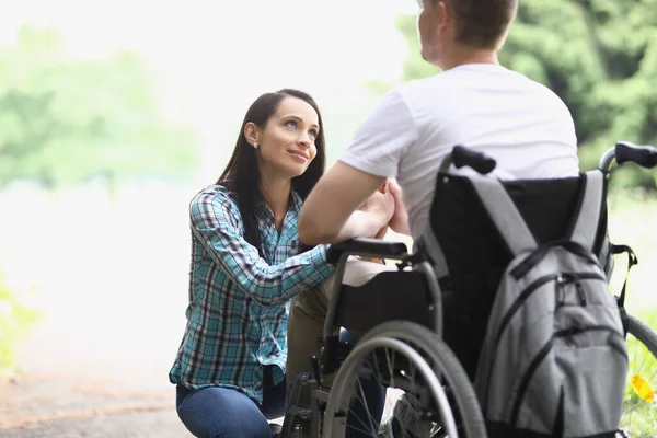 Kvinna tittar med kärleksfull blick på man i rullstol — Stockfoto
