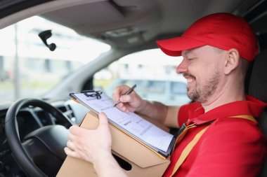 Arabadaki gülümseyen kurye sürücü belgeler ve kutuyla