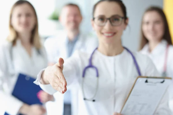 Ärztin streckt vor Ärztekollegen die Hand zur Begrüßung aus — Stockfoto