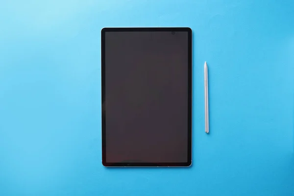 Tablet toque moderno com caneta encontra-se no fundo azul — Fotografia de Stock