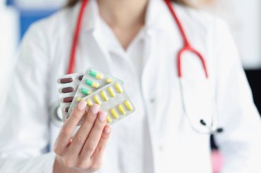 Doktorun elinde tıbbi muayenehanede haplar var.