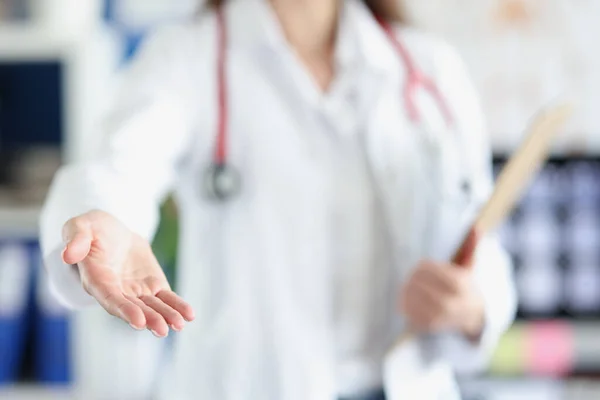 Vrouwelijke arts steekt haar hand uit in vriendelijk gebaar — Stockfoto