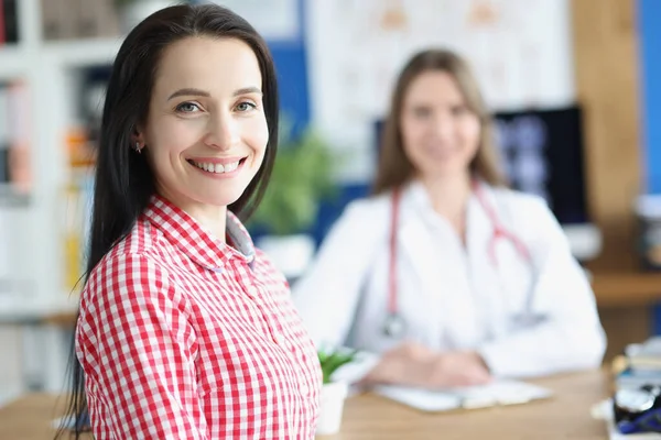 Sonriente paciente joven en el fondo del médico en el consultorio médico —  Fotos de Stock