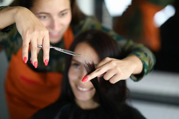 Parrucchiere donna taglia punte di cliente in salone di bellezza — Foto Stock