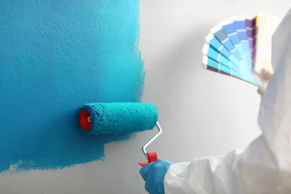 Mester festő tartja a kezében színes paletta árnyalatú kék — Stock Fotó