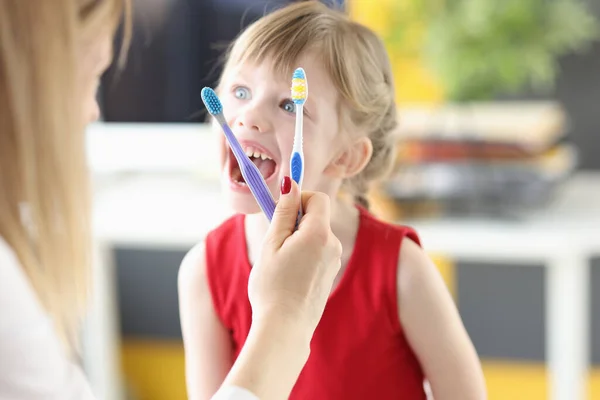 Dentista mostra escovas de dentes menina e movimentos corretos para cuidados orais — Fotografia de Stock