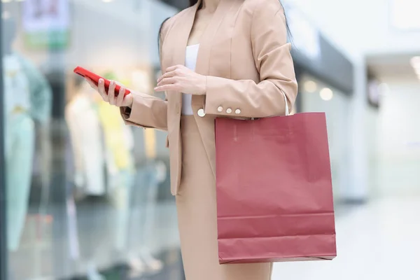 Силуэт деловой женщины со смартфоном в руке и покупками в торговом центре — стоковое фото