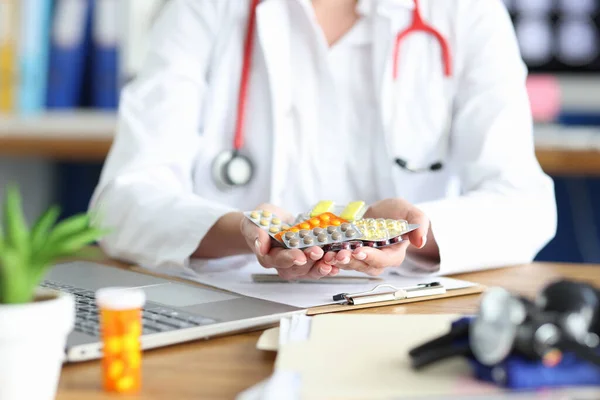 Kvinnlig läkare håller olika mediciner i sina händer — Stockfoto