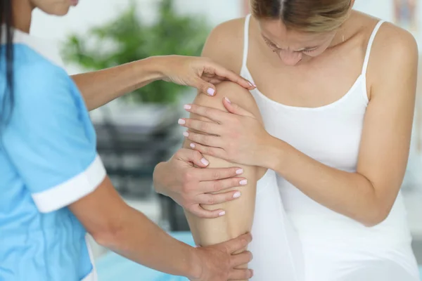 Ortopedik travmatolog randevusunda bacak ağrısı olan bir kadın. — Stok fotoğraf