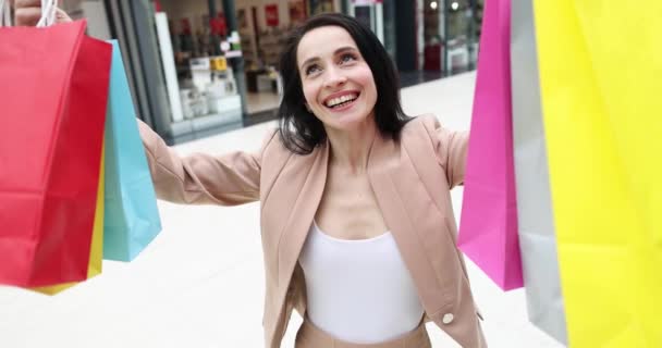 Jeune femme heureuse ramasser des sacs à provisions colorés film 4k — Video