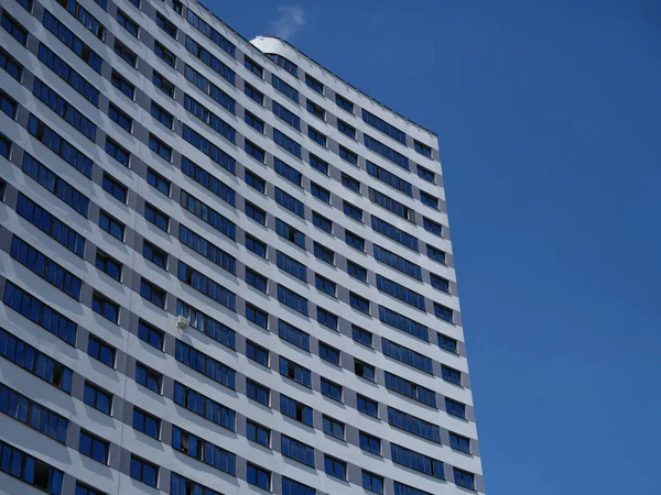Hermoso edificio residencial de varios pisos de pie sobre fondo azul —  Fotos de Stock