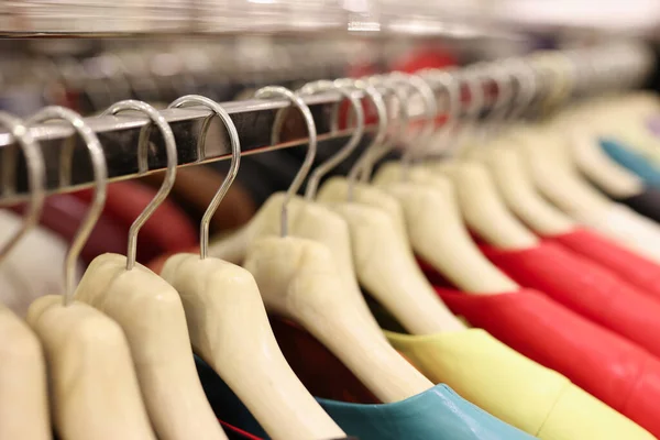 Colorful clothes hang on hangers in mall Stock Picture