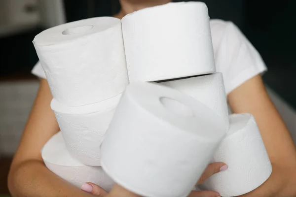 Les mains féminines tenant de nombreux rouleaux de papier toilette blanc gros plan — Photo