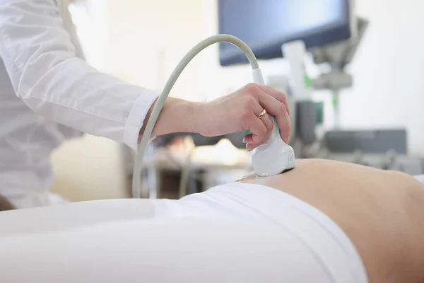 Dispositivo de escáner de ultrasonido en mano del médico profesional que examina a su paciente — Foto de Stock