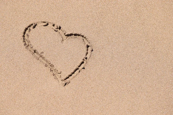 Намальований знак серця на мокрому піску на береговій лінії — стокове фото