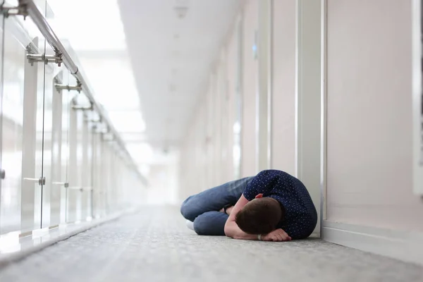 Giovane uomo dorme sotto la porta del complesso alberghiero — Foto Stock