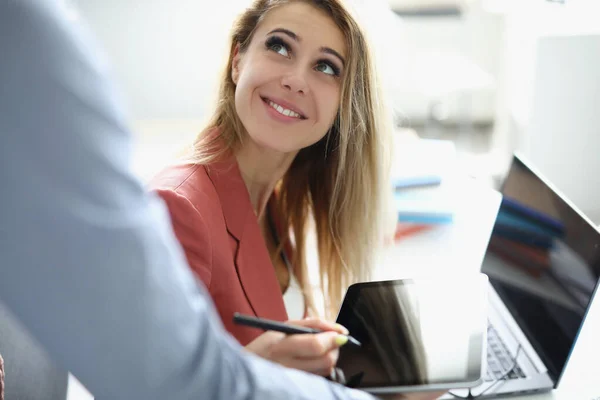 Mujer de negocios sonriente sosteniendo lápiz colega masculino sostiene su tableta — Foto de Stock