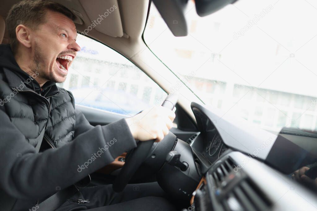 Angry screaming male driver driving car closeup
