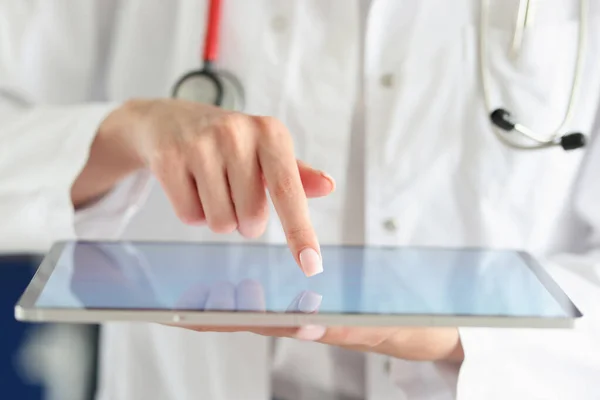 Doctor poniendo su dedo en la pantalla táctil de la tableta digital en primer plano clínica — Foto de Stock