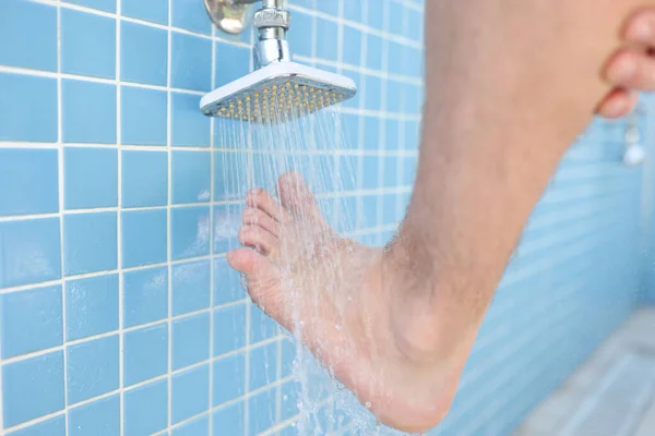 Man washes his foot in pool showe — Stock Photo, Image