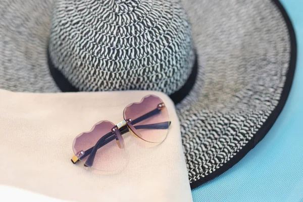 Kadın şapkası ve güneş gözlüğü güverte sandalyesinde yatıyor. — Stok fotoğraf