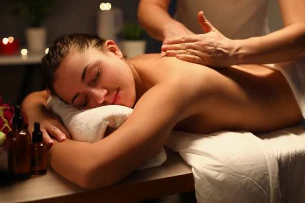 Mujer joven relajándose durante el masaje de espalda en el spa — Foto de Stock