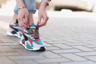 Spor ayakkabılarına ayakkabı bağlayan kadın. Yakın plan.