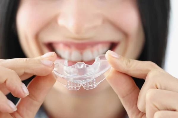 Mulher sorrindo segurando protetor de boca de plástico para clareamento dos dentes — Fotografia de Stock