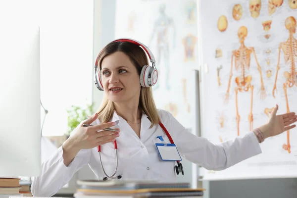 Femme médecin dans les écouteurs effectue une formation en ligne en médecine — Photo