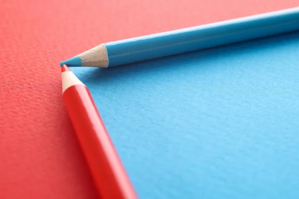 Blue and red pencils on red and blue background