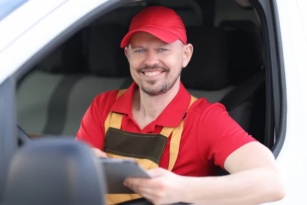 車の窓に文書を保持する男性宅配ドライバーの笑顔肖像画 — ストック写真
