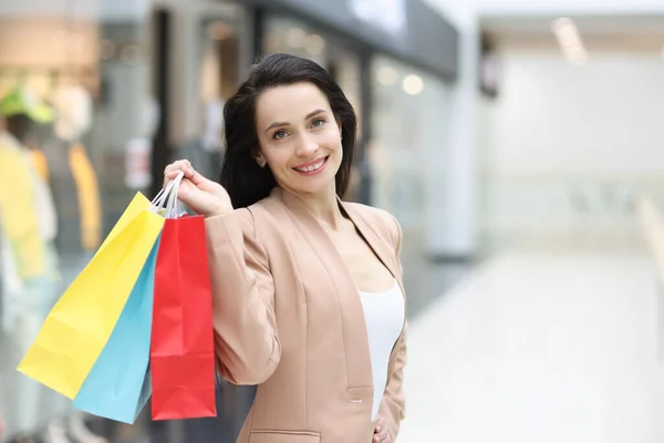 Retrato de mujer elegante sonriente sosteniendo bolsas de compras en el centro comercial — Foto de Stock